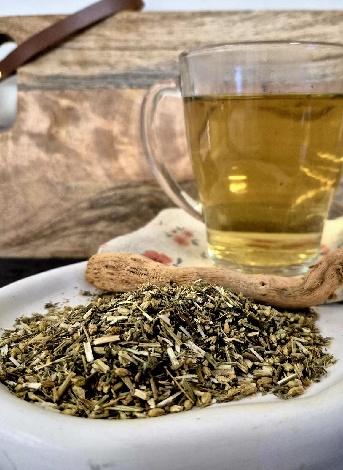 Bio Schafgarbenkraut geschnitten von Hofkraut auf Teller mit frisch aufgebrühtem Tee