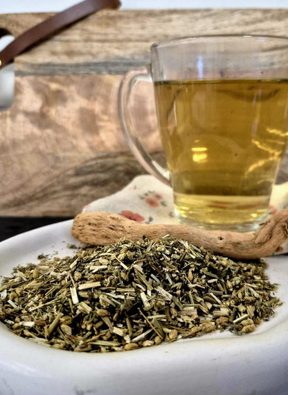 Bio Schafgarbenkraut geschnitten von Hofkraut auf Teller mit frisch aufgebrühtem Tee